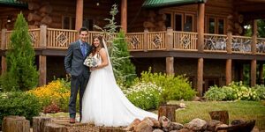 wedding couple posed in front of a smoky mountain cabin