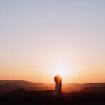 bride and groom kissing with a smoky mountain sunset backdrop
